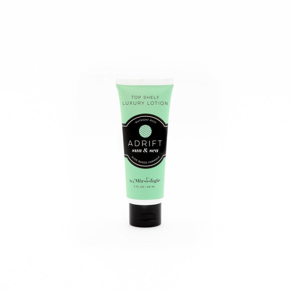 Adrift (Sun & Sea) Top shelf lotion in light green tube with black lid and label. Nutrient rich, aloe based formula, tube has 5 fl oz or 89 mL. Pictured with white background.